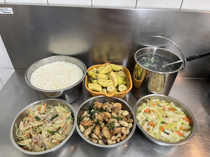 午餐：(營養糙米飯)、鹽酥雞柳、洋蔥燜肉絲、季節時蔬、薑絲蛤蜊湯、四季水果